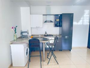 a kitchen with a counter with chairs and a table at YOUR HOME in Agadir