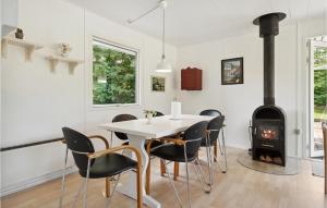 a dining room with a table and chairs and a fireplace at 3 Bedroom Amazing Home In Børkop in Børkop