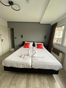 a bedroom with a large white bed with red pillows at Amsterdam Soul Inn in Amsterdam