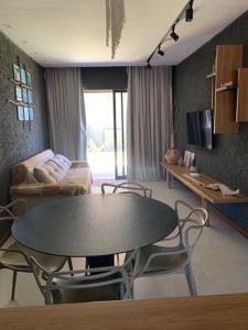 a living room with a table and chairs and a couch at Patacho Porto Gamboa in Pôrto de Pedras