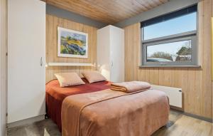 a bedroom with two beds and a window at Holiday Home Bøsholmstien Glesborg Denm in Fjellerup Strand