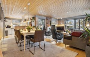 a dining room and living room with a table and chairs at Holiday Home Bøsholmstien Glesborg Denm in Fjellerup Strand