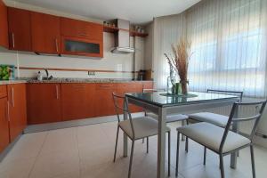 a kitchen with a glass table and chairs in it at La Fontana in Santa Marta de Tormes