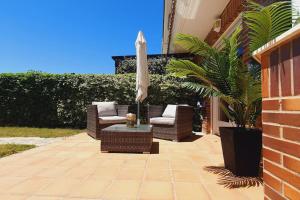 a patio with chairs and an umbrella and a table at La Fontana in Santa Marta de Tormes