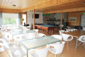 a room with tables and chairs and a pool table at Auberge St-Tite-des-Caps in Saint-Tite-des-Caps