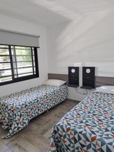 a room with two beds and two speakers at Tango Departamento in Santa Teresita