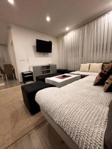 a living room with a couch and a tv at Guest House deluxe in Orašje