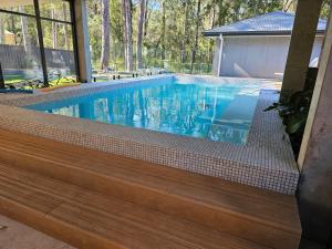 圣殿海岬Sanctuary On the Creek的蓝色房子中的游泳池