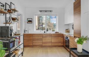 a kitchen with wooden cabinets and a window at 4 Bedroom Cozy Home In København S in Copenhagen