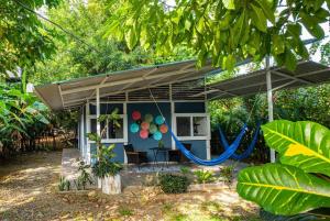 a blue house with a porch with a swing at Luz Tropical in Puerto Viejo
