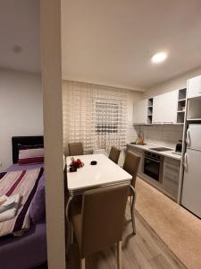 a kitchen and dining room with a white table and chairs at Guest House deluxe in Orašje