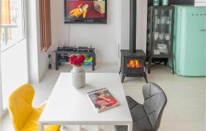 a living room with a table and a fireplace at Lovely Home In Taszów With Sauna in Taszów