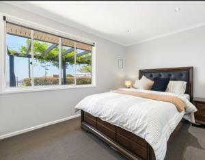 谭伯连山Stunning home with view的一间带床和大窗户的卧室