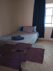 ein Schlafzimmer mit einem Bett mit blauen Kissen und einem Fenster in der Unterkunft La casa de Lulu in Miraflores