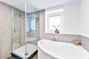 a white bathroom with a tub and a shower at WHONAP - DE HYDDAN I Parkplatz I Zentral I Terrasse I Küche in Möckmühl +42 photos