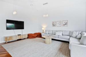 a living room with a couch and a tv at House on the Hillside with City Views Sleeps 12 in Howrah