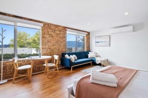 a bedroom with a blue couch and a brick wall at House on the Hillside with City Views Sleeps 12 in Howrah