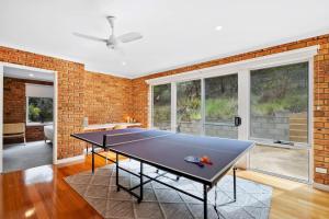 a ping pong table in a room with a brick wall at House on the Hillside with City Views Sleeps 12 in Howrah