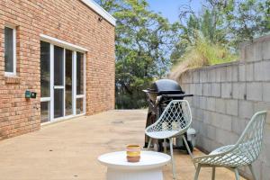 a motorcycle parked next to two chairs and a table at House on the Hillside with City Views Sleeps 12 in Howrah