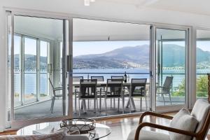 a living room with a table and a view of the ocean at House on the Hillside with City Views Sleeps 12 in Howrah