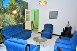 a living room with blue couches and chairs at Tambarina Guest House in Mindelo