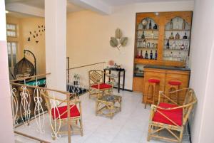 a room with a bar with chairs and a counter at Tambarina Guest House in Mindelo