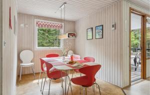 ein Esszimmer mit einem Tisch und roten Stühlen in der Unterkunft Holiday Home Hc Møllersvej Nexø in Bedegård