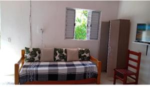 a living room with a couch and a window at Kitnet da Adriana in Paraty