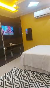a bedroom with a bed and a flat screen tv at Casa da iluminada in Belém