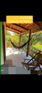 a hammock under a building with a sign that reads boichenchin do m at BOIPEBA Cantinho do Mirko 1 in Cayru
