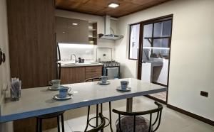 a kitchen with a table and chairs with cups on it at Departamento en centro de Cuenca in Cuenca