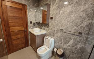 a bathroom with a toilet and a sink at Departamento en centro de Cuenca in Cuenca +23 photos