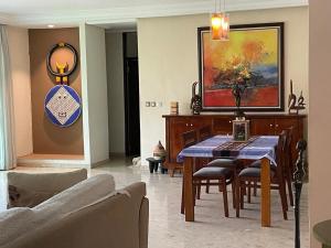 a dining room with a table and chairs and a painting at Maison Katia in Abidjan