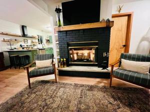 ein Wohnzimmer mit einem Kamin und 2 Stühlen in der Unterkunft Cozy Cottage by the Lake in Albrightsville