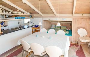 ヒアツハルスにあるHoliday Home Klitrenden Hirtshals Viのテーブルと椅子のあるキッチンとダイニングルーム