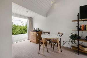 a dining room with a table and chairs and a window at Hawthorn Cottage - Deluxe Private Guesthouse in Tamahere
