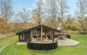 a small black house with a deck in the grass at Holiday Home Knold-Åsen H-617 in Vejby +18 photos