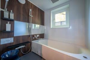 余市にあるThe Chateauのバスタブと窓のあるバスルーム