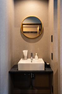 余市にあるThe Chateauの白い洗面台と鏡のあるバスルーム