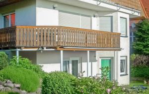 a house with a deck on the side of it at Ferienwohnung Rheinsberg in Kunkelberg +8 photos