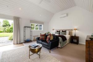 a large bedroom with a bed and a couch at Hawthorn Cottage - Deluxe Private Guesthouse in Tamahere +17 photos