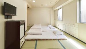 帯広市にあるホテルパコ帯広中央(旧ホテルパコ帯広3)のベッド3台、薄型テレビが備わる客室です。