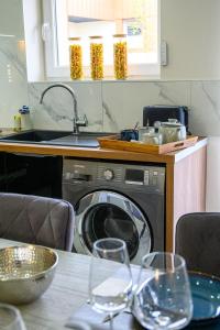 una cucina con lavatrice e bicchieri su un tavolo di Le Charles 1 a Montbéliard