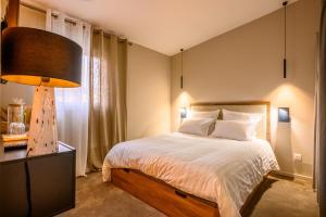 una camera con un grande letto e una lampada di Le Charles 1 a Montbéliard