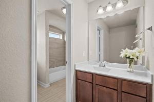 a bathroom with a sink and a vase of flowers at Gated Community 2-story Home2 in Rosenberg