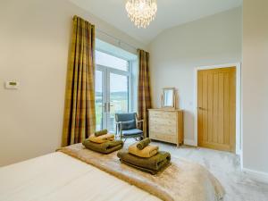 une chambre avec un lit avec une chaise et une fenêtre dans l'établissement Merry Burn Barn - Uk3325, à Falstone 20 autres photos