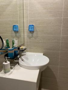 a bathroom with a white sink and a mirror at Modern studio apartment - C House in Gò Công