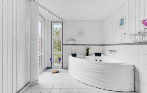 a white bathroom with a tub and a window at Holiday Home Rævebæk Sydals V Denmark in Skovby +16 photos