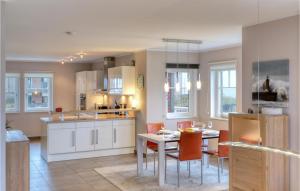 a kitchen and dining room with a table and chairs at Unendliche See in Olpenitz
