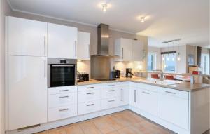 a white kitchen with white cabinets and appliances at Unendliche See in Olpenitz